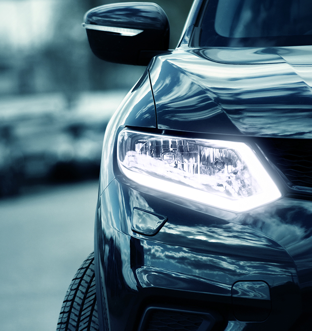 Phare LED de SUV moderne : design et éclairage automobile Phare LED allumé d'un SUV noir brillant avec reflets de nuages sur la carrosserie et rétroviseur extérieur.